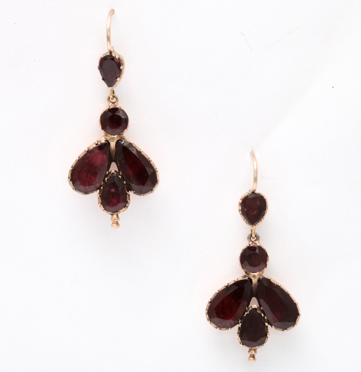 Georgian gold and garnet earrings c. 1820 are 15kt gold with foiled garnets. The form, an unusual shape, looks more like an insect than it does the floral form of small garnet earrings we see more often. As there was no electricity at this time,