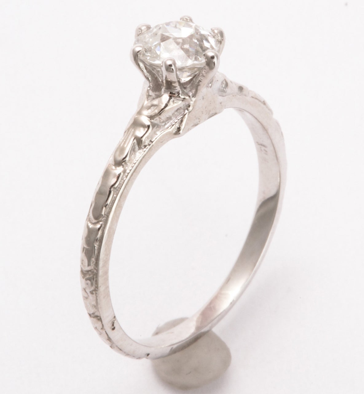 Those who treasure petite diamond rings and bands of tiny diamonds will breathe a sigh at the sweetness of this .50 ct diamond.  The setting is hand made in 14 kt white gold. The band displays raised repousse engraving.  The diamond, constant in