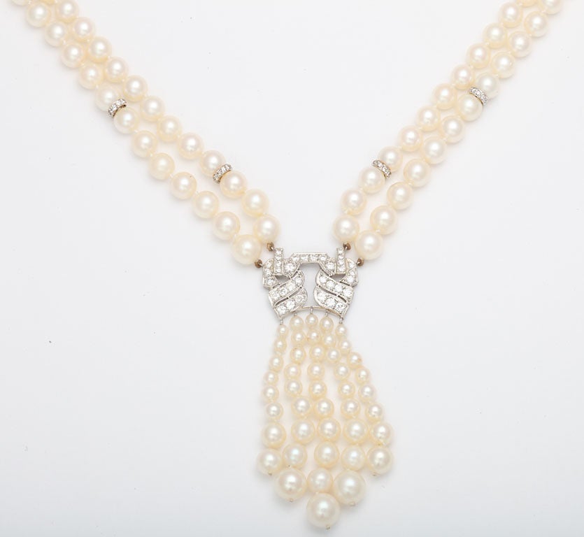Double strand Cultured Pearl Necklace interspersed with 8 Diamond set Rondels, and centered with a Platinum & Diamond Element & terminating with a graduated Pearl Tassel.