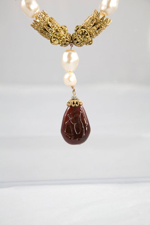 Absolutely beautiful sautoir by the House of Chanel! Comprised of both red and green poured glass stones, along with glass pearls, the stones are set off by fine and lace-like filigree in gold tone metal. This piece is a rare example of the kind of