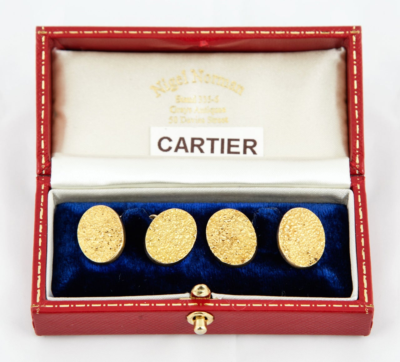 A heavy pair of 18ct,yellow gold oval cufflinks of stippled design,
signed Cartier and numbered,c,1950