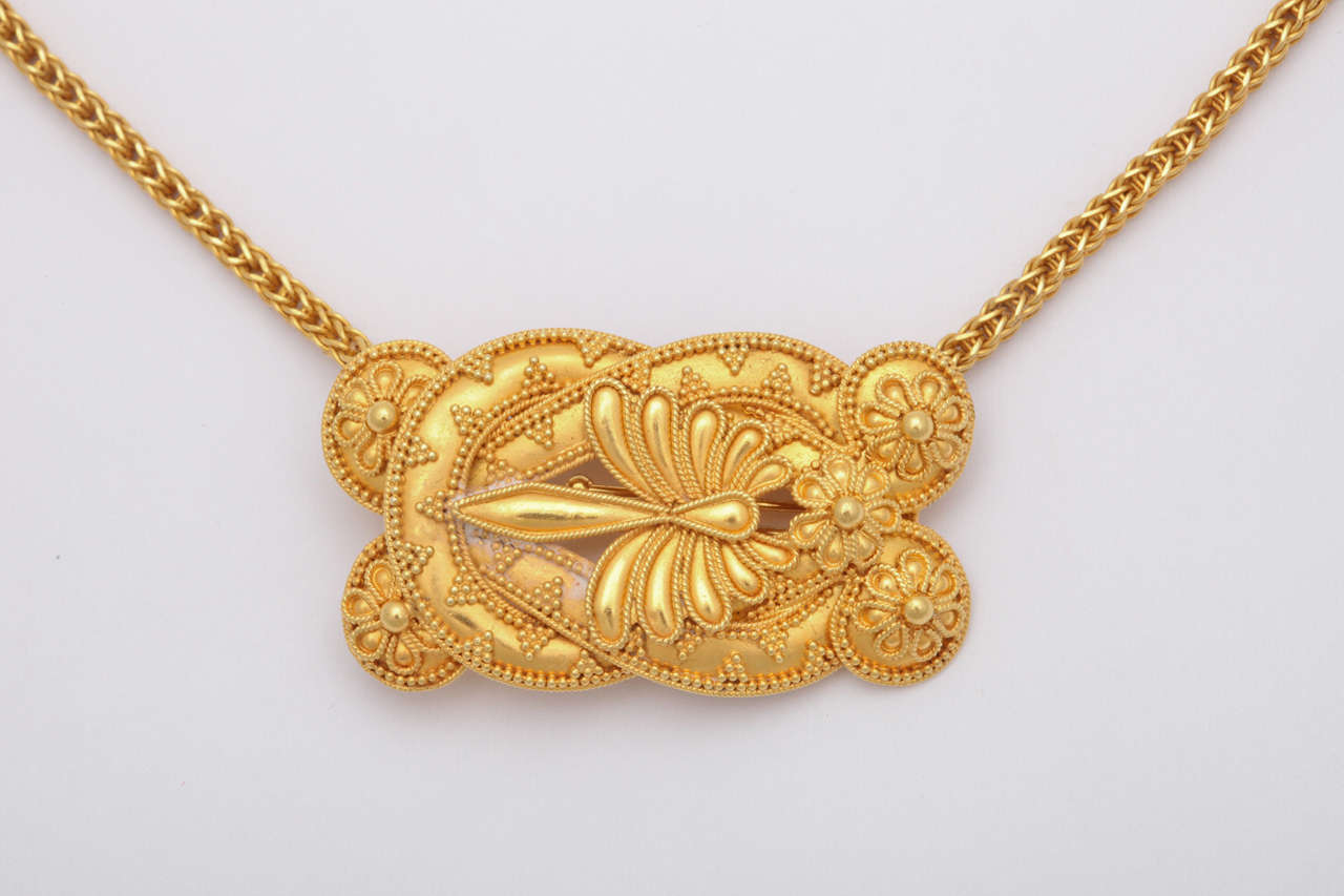 22kt Gelbgold Pin mit Halterungen, um eine Halskette zu konvertieren.  Aufgehängt an einer handgefertigten 18kt Gelbgold gewebten Kette.  Beide Stücke sind im klassisch-hellenistischen Stil gehalten.  Hergestellt in den späten 50er- und frühen