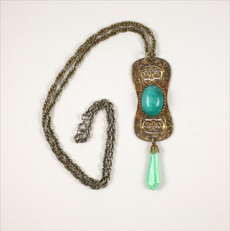 Goldtone filigree pendant with prong set faux jade cabochon and drop suspended from a chain.