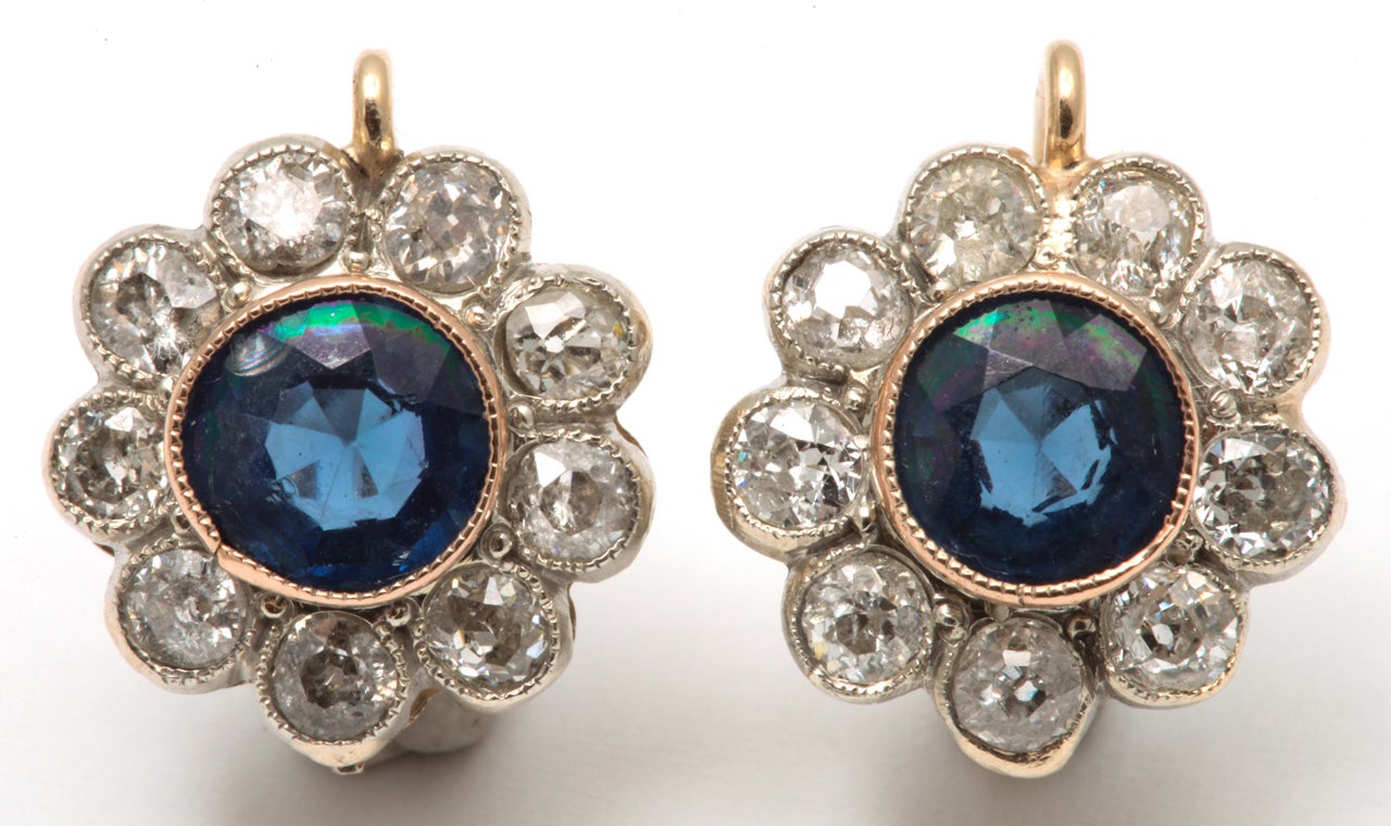 18kt yellow gold and platinum floral cluster earrings consisting of .75ct each Ceylon sapphires in center and  bordering approximately 3 carats of old mine cut diamonds