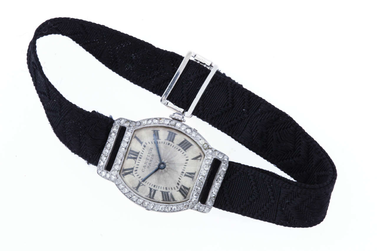 Cartier platinum, diamond  and 18K yellow gold Art Deco Tortue wristwatch, circa 1925. An extremely rare wristwatch with a grosgrain ribbon bracelet. The 20mm x 26mm tonneau case has a  yellow gold back with 4 screws in the platinum band. The bezel,