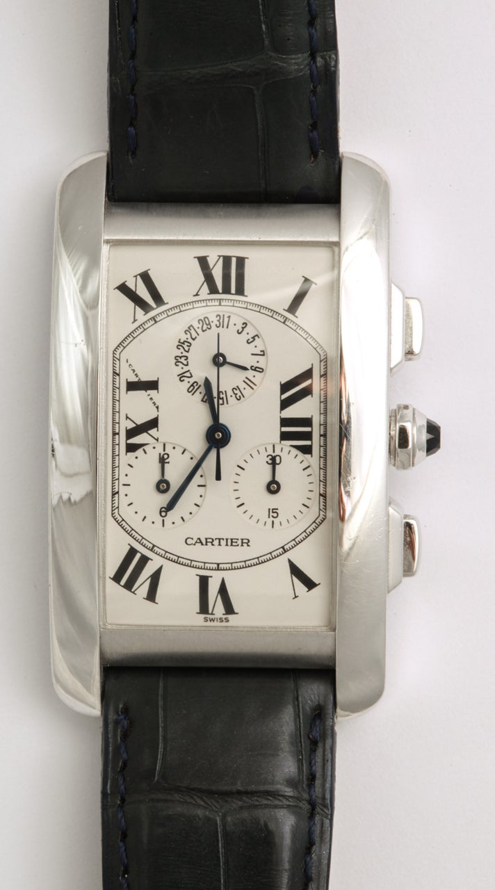 Cartier White Gold Tank Americaine Chronoflex Chronograph Wristwatch

Metal: 18k white gold 
Case:  26 mm 
Dial:  Silvered dial with black Roman numerals
Features: Secret signature at 'X', date sub-dial at 12 o'clock, minute register at 4