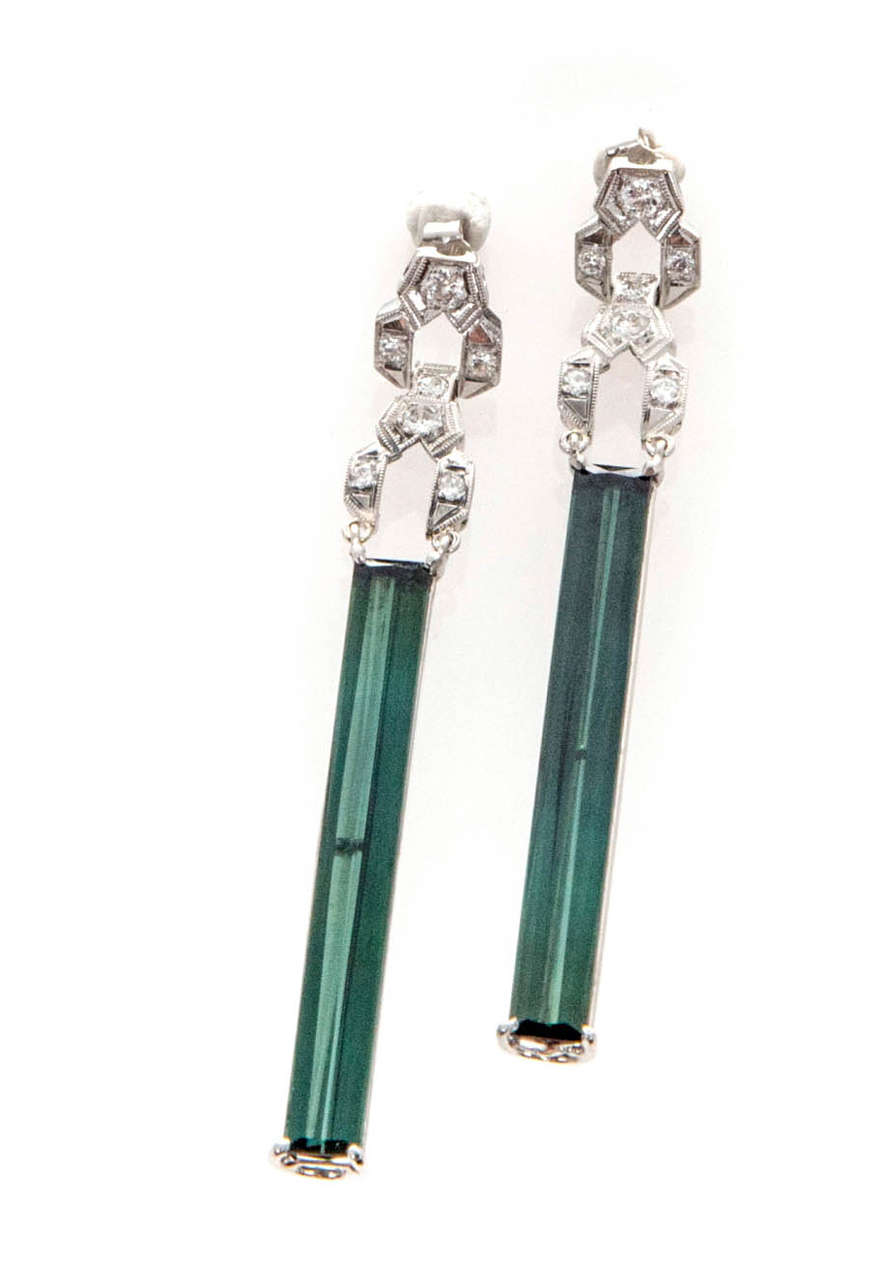 Very special one of a kind elongated Emerald cut fine green tourmaline dangle earrings. Extra-long and narrow. Beautiful green color. Circa 1920-1930.

Platinum
14 round diamonds, approx. total weight .16cts, G, VS
2 elongated Emerald cut green