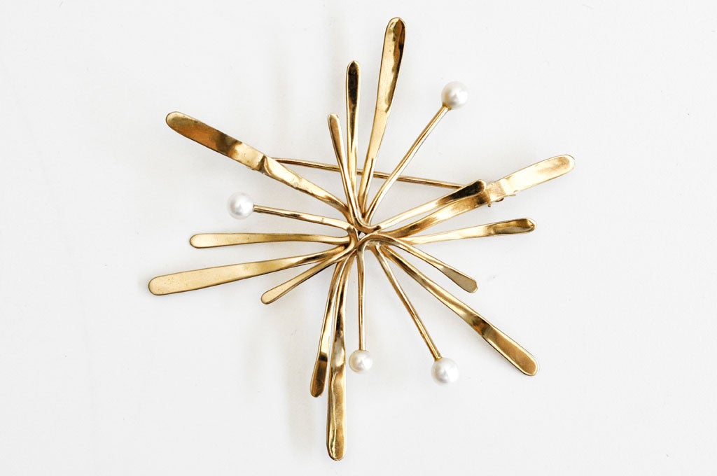 This extraordinary, gold pin by Merry Renk (1921-2012) reflects her interest in creating organic forms and her fascination with the structure of jewelry.  A dynamic, starburst design, typical of the period, and a fine example of mid-century American