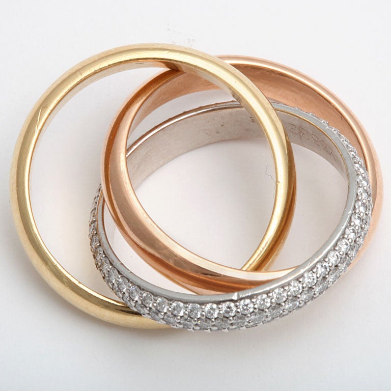 Signed Cartier, this three row band features an 18k yellow and rose gold and a white pave diamond band, 1.18 cts.  The band meaures 4 mm. Size 54 (7). Great Loooking!!