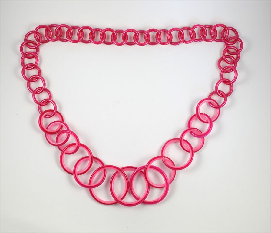 Graduated pink plastic loop necklace. Largest loop is 2  1/8