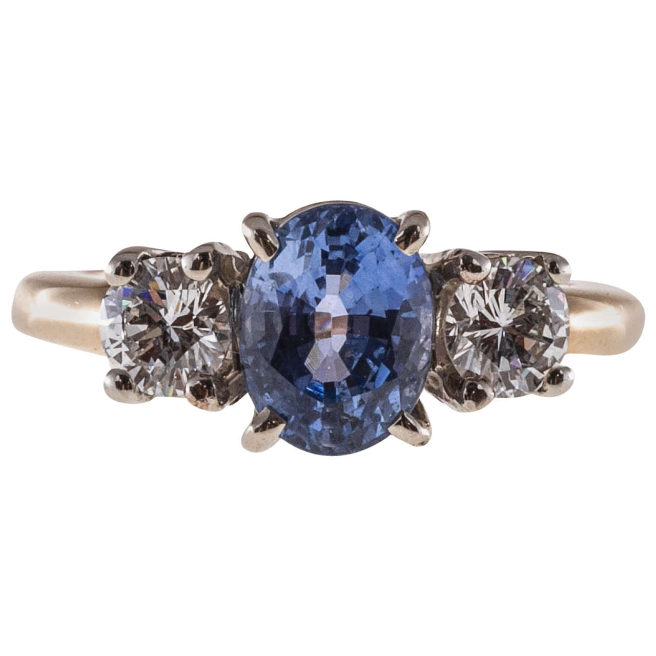 Untreated no heat medium bright blue oval Sapphire and round white diamond three-stone engagement ring in a 14k yellow white gold setting.

1 natural untreated oval medium bright periwinkle blue Sapphire, approx. total weight 2.14cts, VS2, 8.05 x