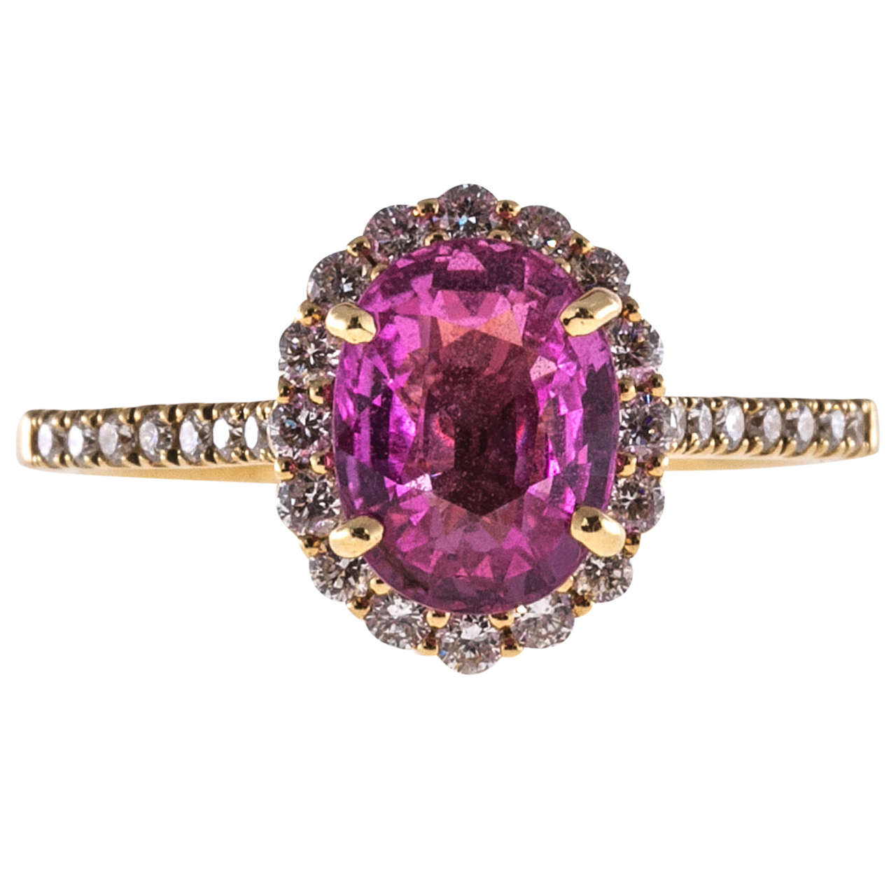 Bright pink oval Sapphire simple heat only in a beautiful oval halo of diamonds in a an 18k yellow gold setting with white diamond accents. A wedding band will fit flush against the ring.

1 oval bright pink Sapphire, approx. total weight 2.41cts,