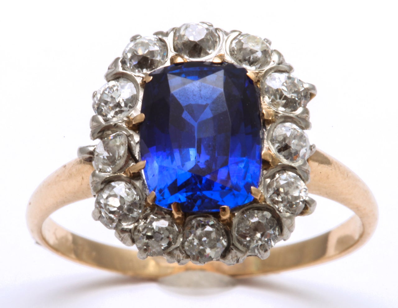 Glorius 2.81ct Faceted Sapphire surrounded by 12 old mine Diamonds  totaling 1.5cts.   Platinum top and 14kt yellow gold shank.  Size 7.25 but can be sized.