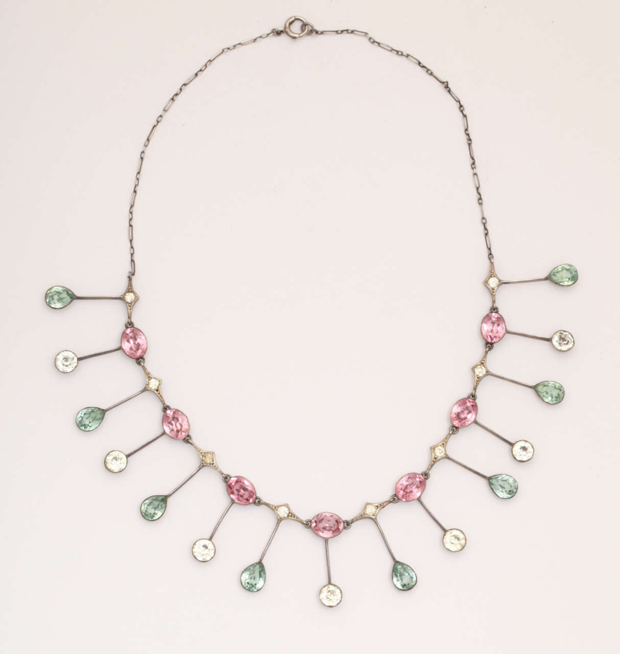 Set in sterling silver circa 1900, a rare array of aqua, pink and clear pastes sit on the neck like rays of the sun. I have not seen this design before and it is sublime.  Fifteen rays emanate from pink and clear pastes and from diamond shaped