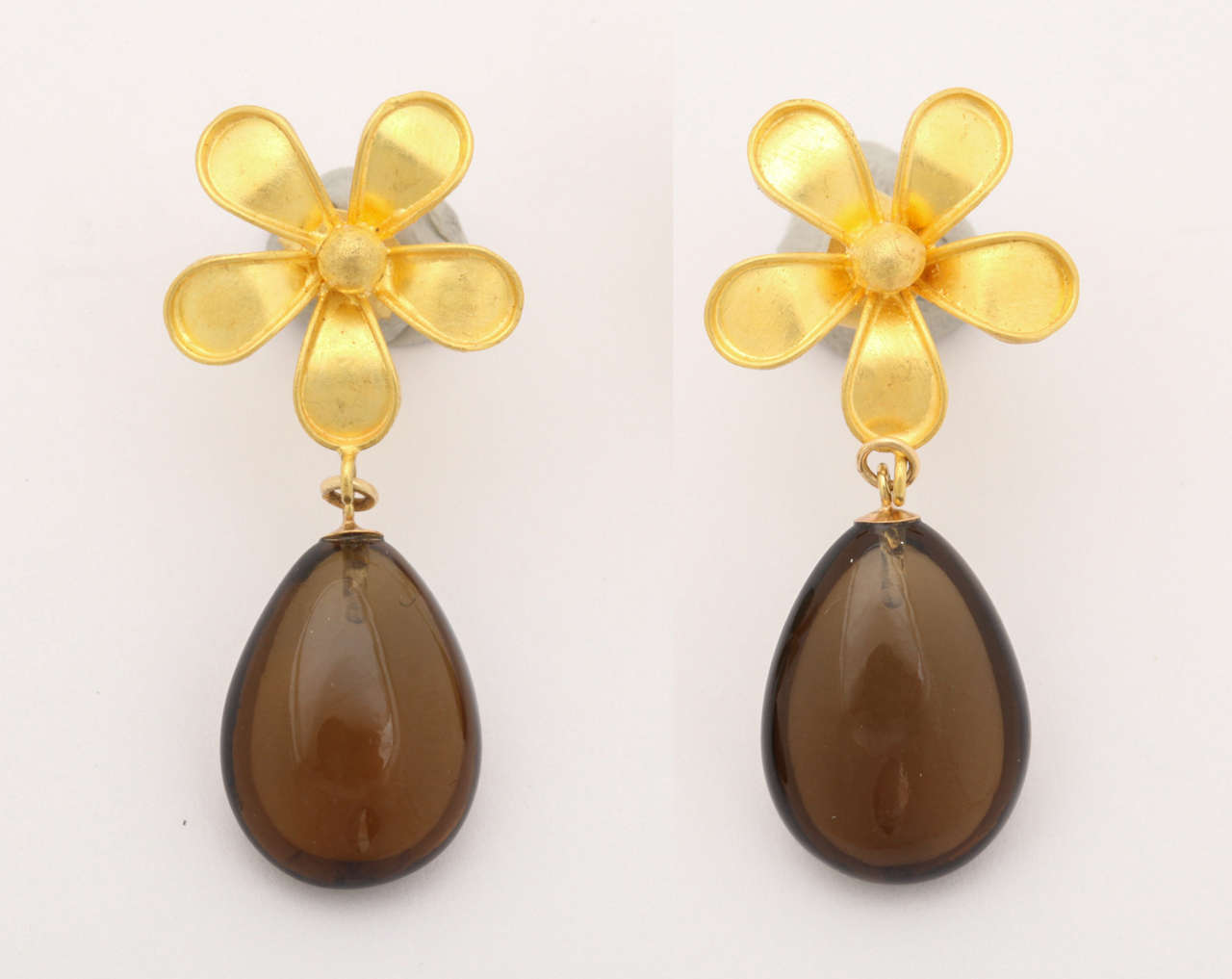 Lovely 22 kt flower earring tops with smoky quartz cabochon pear shaped  drops gracefully dangling. The combination of the rich gold color and smoky quartz drops are great for the fall. The drops are smooth and beautifully cut to give a nice glow as