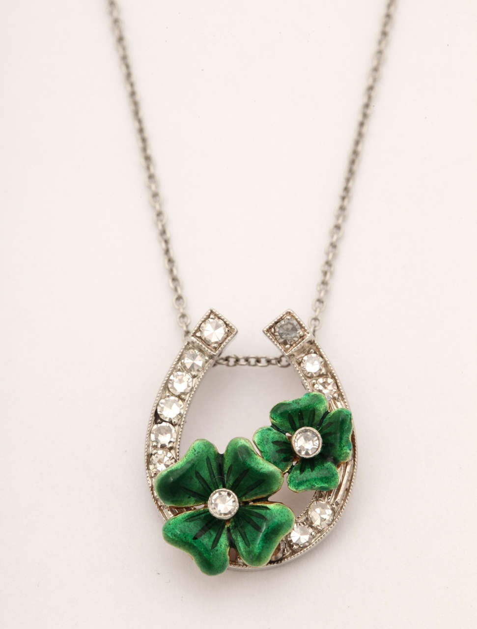 A classical Good Luck token for the horseracing enthusiast or signifying good fortune in any endeavor. This pendant is made in the king of metals, platinum, enhanced with brilliant diamonds and 2 green enamel four leaf clovers.The chain is 17.5 in.