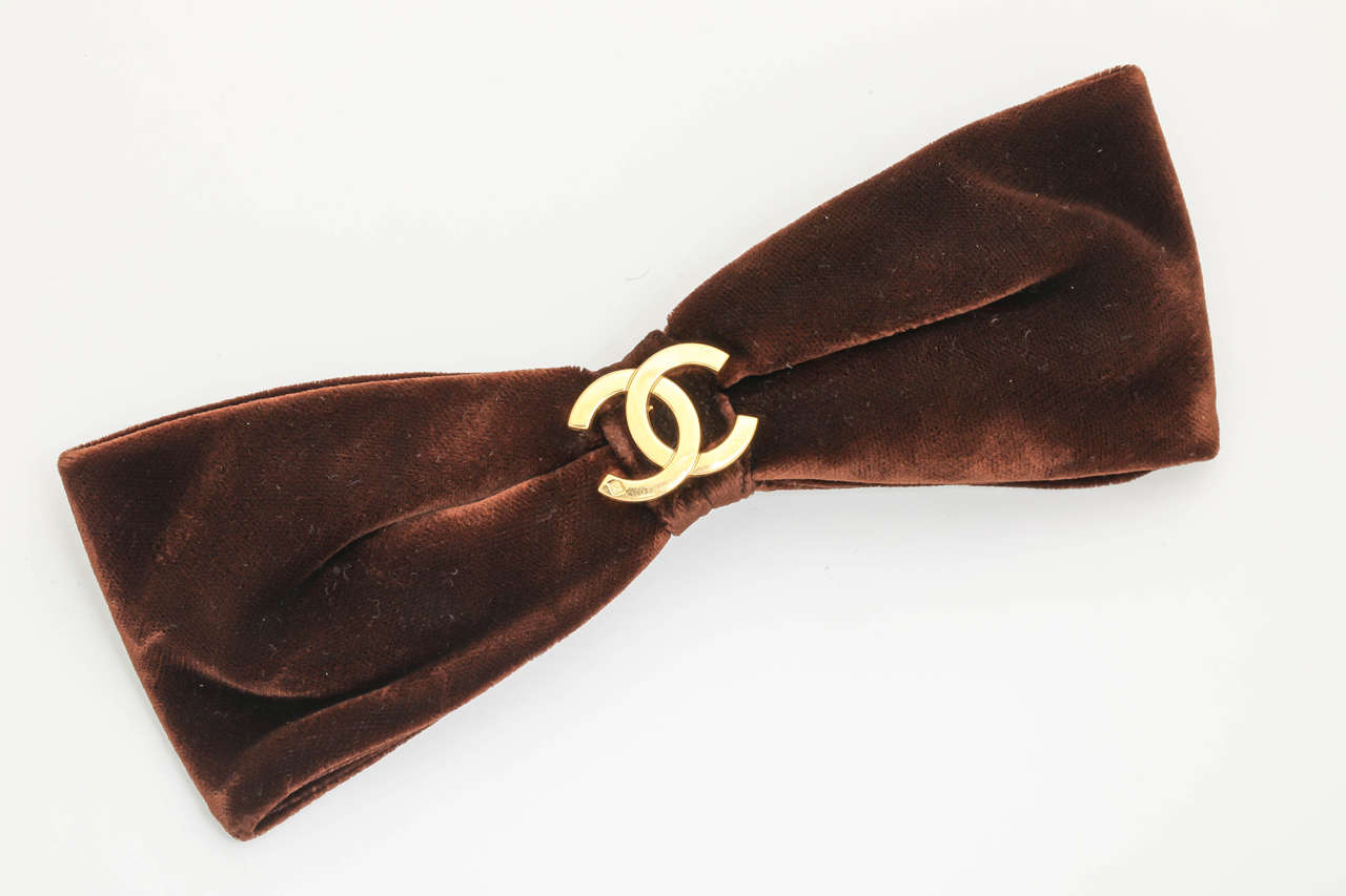 Very rare Chanel large bow hair clip with gold CC logo. Made of brown velvet fabric.