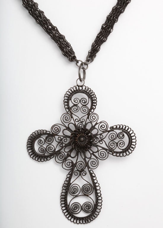 Here is a mix of texture, both substantial and lacy. An extremely rare, dense Berlin Iron Chain c.1800 suspends a large cross of twists and loops. In the chain, the iron is woven or knit into strong, mesh. There is a similar example of this chain in