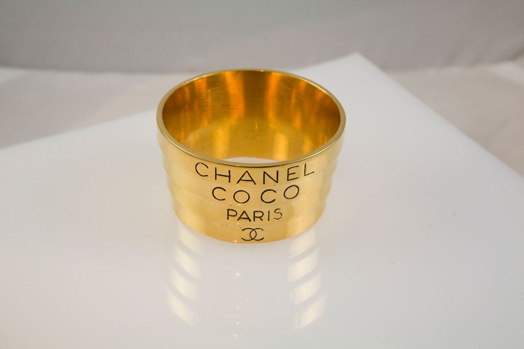 Unusual fixed telescoping bracelet from the runway of Chanel.  This bracelet is very unusual and is somewhat heavy.  Gold plated metal featuring the words 