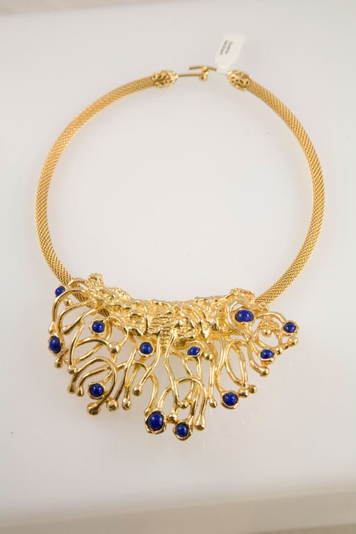 Beautiful choker consisting of a braided ring and featuring a striking modernist embellishment set with deep blue stones.