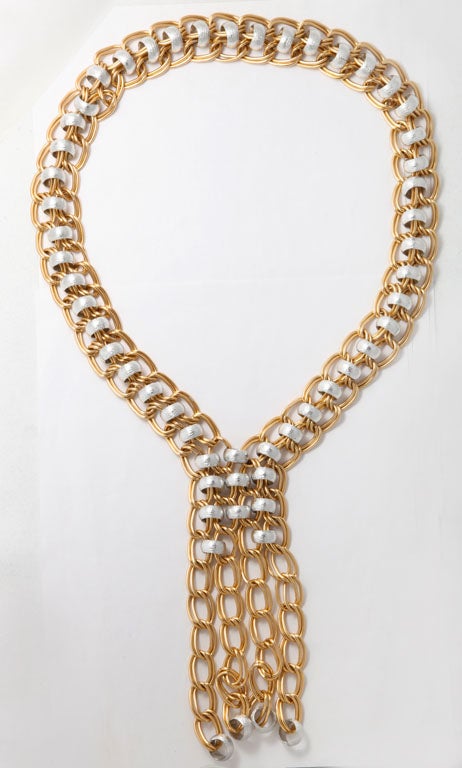 Large link gold tone necklace with silver tone rings.
