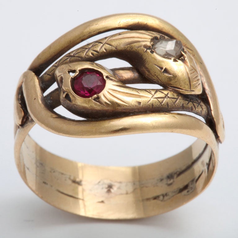 Cross hatch engraving on 15 kt gold represents the scales on the gentle ruby and diamond eyed snakes seen lovingly knotted on this ring. Like a love knot, there is no beginning or end which is why the serpent coiled in this way represents infinite