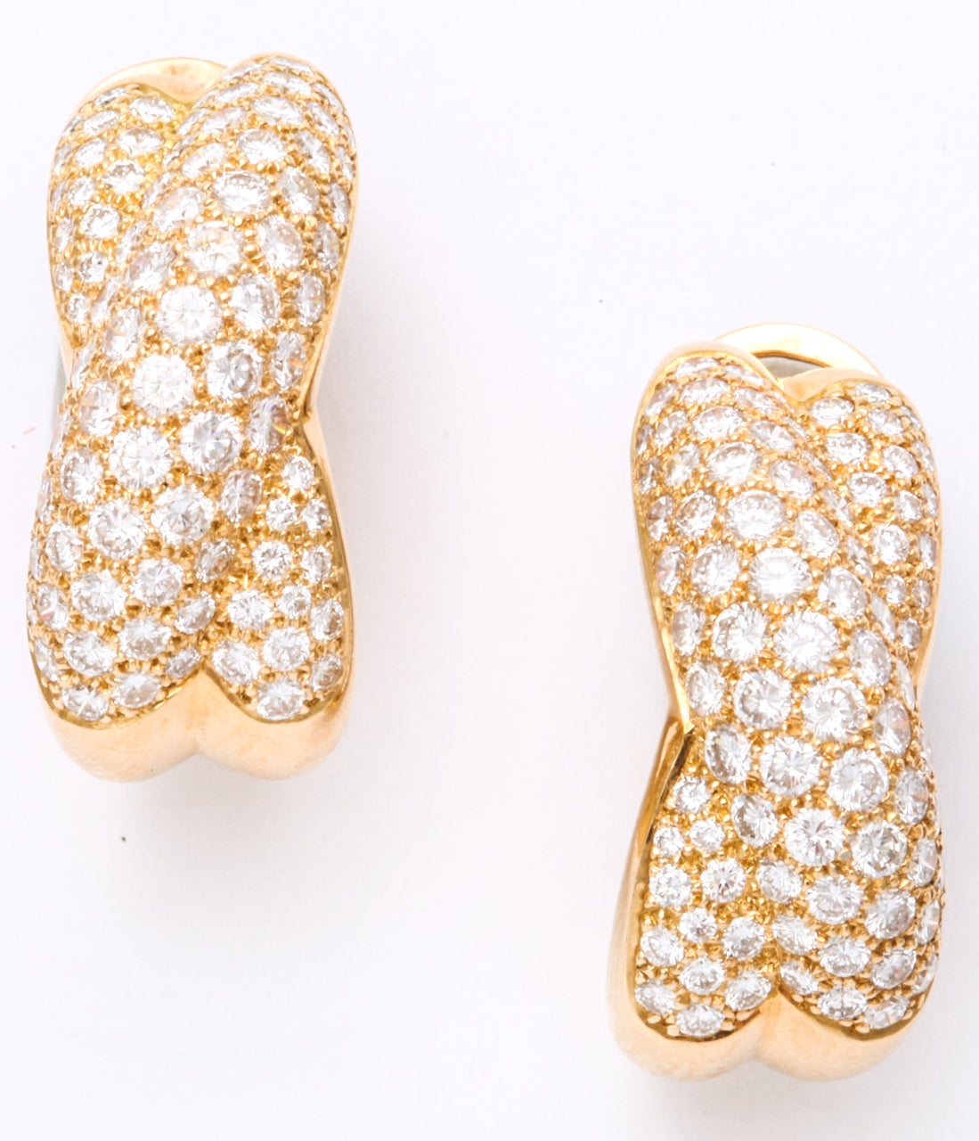 Authentic CARTIER Gold Diamond Crossed Omega Earrings.  Total weight of diamonds - 6 carats approximately. 
Length - 1