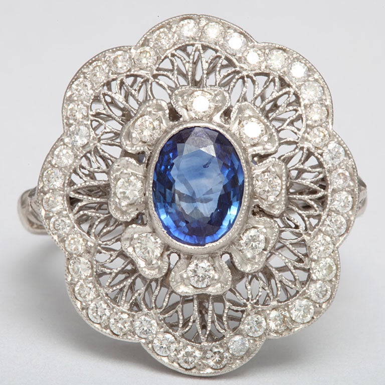 platinum and diamond and natural sapphire ring made in a floral design with handmade open work design finishing touch in back of ring