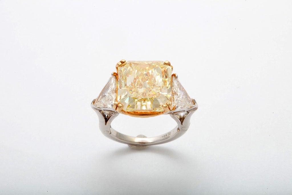 Fancy Yellow Diamond 11.59 carats, accompanied by GIA report  #17173065 (Fancy Yellow,SI1) Flanked by 2 colorless triangle diamonds 2.44 carats total weight. In hand made ring with expandable shank