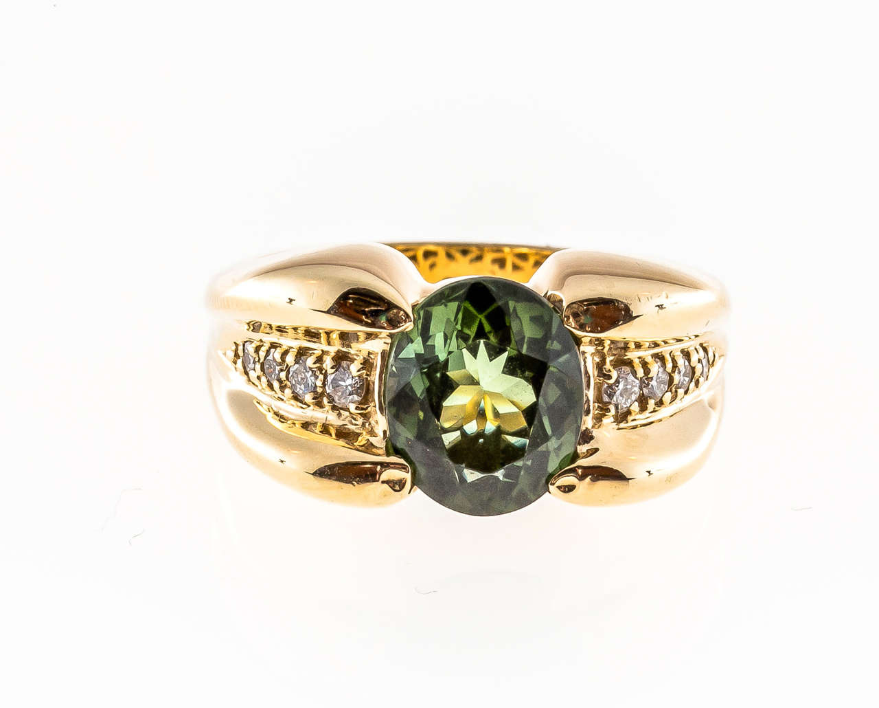 Sonia B oval green Tourmaline ring with raised top and white diamond accents.

1 Oval genuine green Tourmaline 10 x 8mm, approx. total weight 2.90cts
8 full cut round diamonds, approx. total weight .15cts, G-H, VS2-SI1
Stamped: Sonia B 14k
9.3