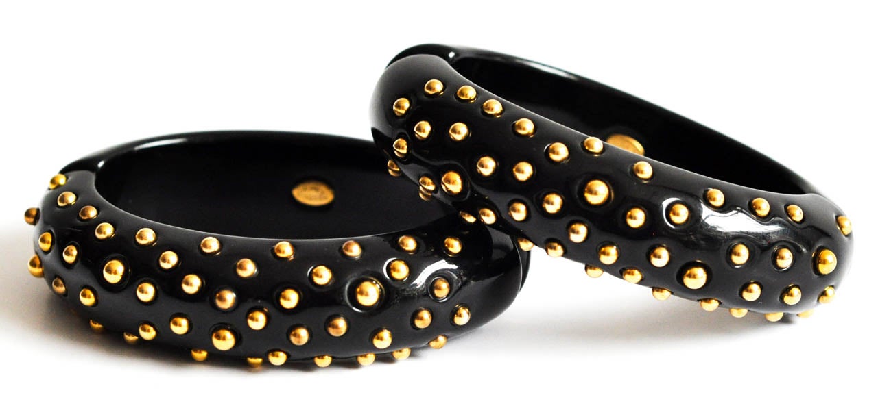 A very cool pair of black hinged bracelets with brass studs by Kenneth Jay Lane.  Both marked Kenneth Lane.  Perfect for a small wrist, could be worn together or separately.  ( Priced as a pair.)