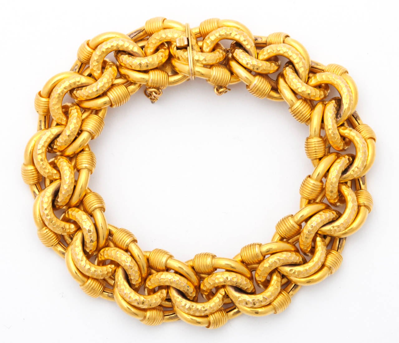 Links, links and more links connect in groups of eight to take the shape of a double pretzel or love knot. The links grasp each other like little claws. Some are faceted, others are smooth and wrapped, thereby making the variety of texture you find