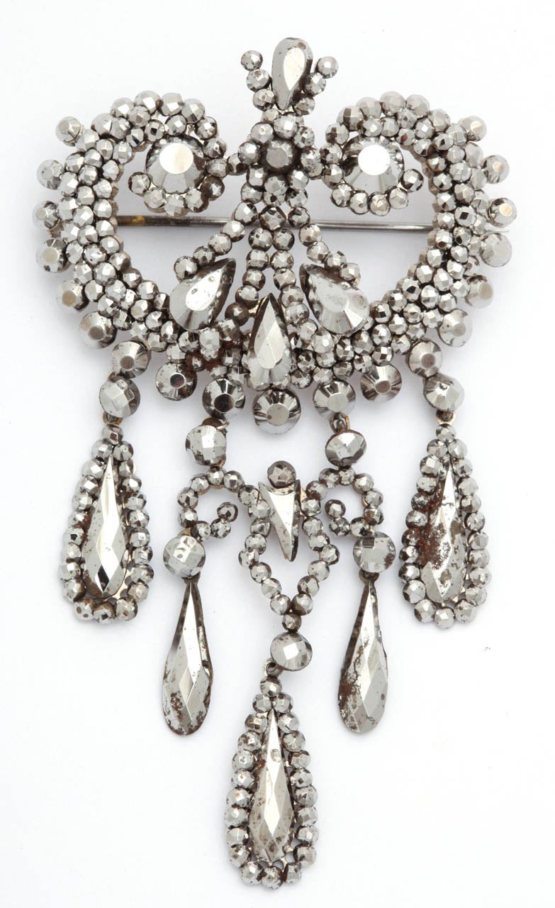 A superb quality example of hand cut steel jewelry c. 1830. The large brooch was made to shine in candlelight. No electric lights were in existence. To attract surrounding light, tiny pieces of steel were faceted like antique diamonds and set into a