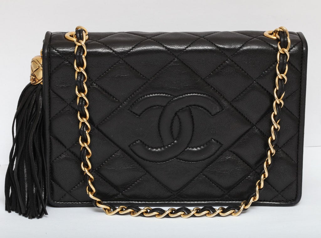 Chanel Vintage quilted bag with tassel in black.<br />
Comes with an authenticity card and a serial sticker.<br />
<br />
Width 8 inches, height 6 inches, depth 2.6 inches, chain length 38 inches.