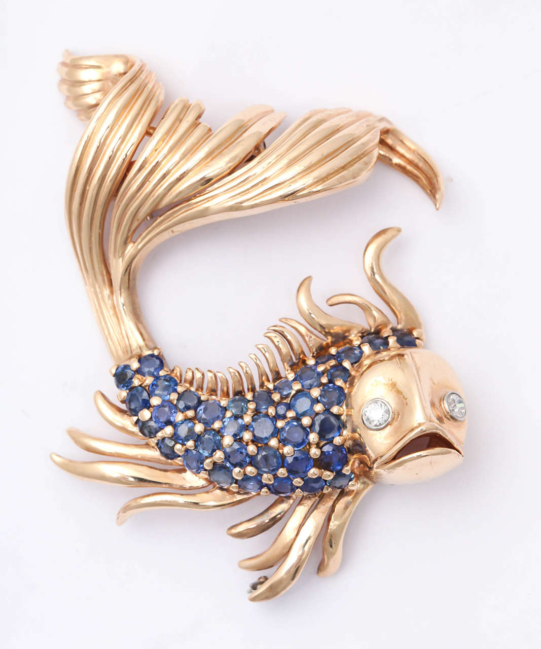 Marvelous 14kt Rose Gold Goldfish Clip - very animated and lively.  Body set with 4-5 carats of lively blue faceted  Sapphires. The eyes are set with Diamonds.
Great for a sporty look or as a dramatic foil for a black evening dress.  One of a kind.
