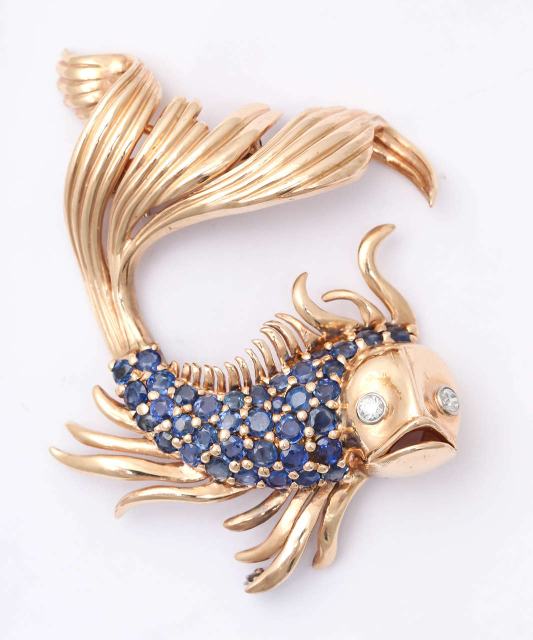 Meravigliosa clip a forma di pesce rosso 14kt Rose - molto animata e vivace.  Corpo incastonato con 4-5 carati di blu vivace sfaccettato  Zaffiri. Gli occhi sono incastonati di diamanti.
Ideale per un look sportivo o come sfondo scenografico per un