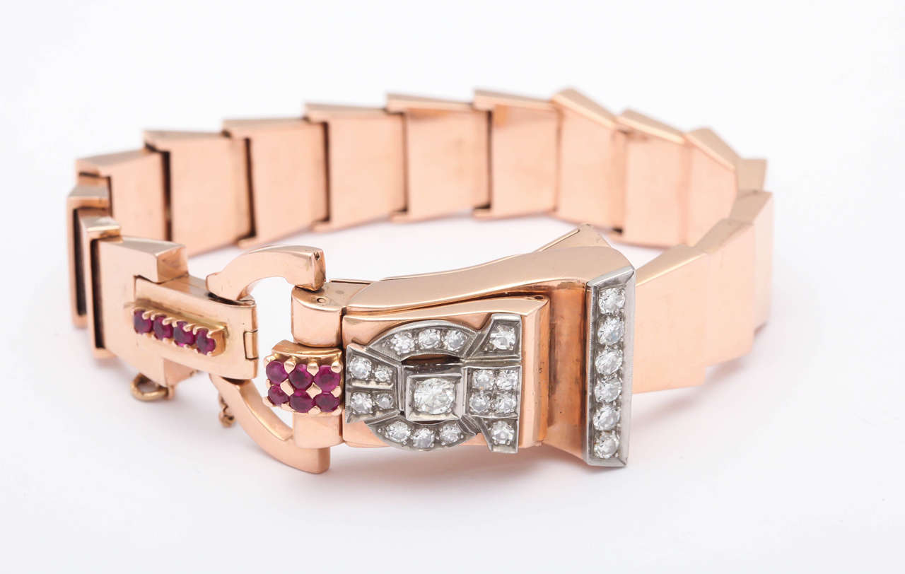 14k Rose Gold, Diamond and Natural Ruby Bracelet Watch with Decorated Concealed Dial and Unusual Stepped-Link Bracelet. Watch Movement Made By Bulova, Fully Functional. The Diamonds Are Full Cut, Clean and White. Circa 1940s.