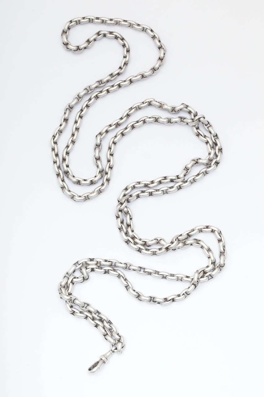 In sterling silver, a chain of satin silver links, both horizontal and vertical. makes a substantial antique flourish. Add a locket or not, it has texture and interest whether worn long, doubled or tripled.  Chains were popular in the Georgian and