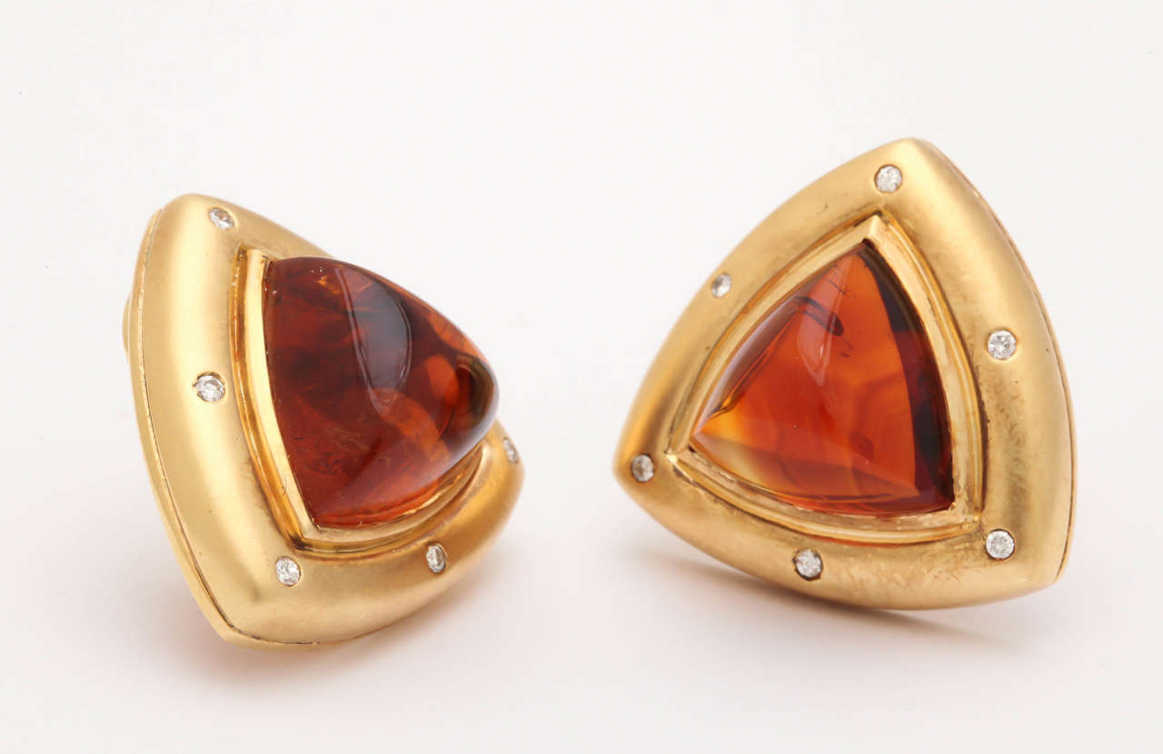 These 18 kt yellow gold large clips earrings are about an inch on each side. The deep, richly colored Madeira citrine triangular  cabochons are bezel set. The 12 diamonds are gypsy set and add sparkle to the soft matte finish of the gold. The ear
