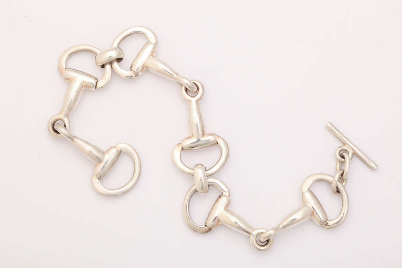 This bracelet is sterling silver and the links are a stylized D ring snaffle bit used in a horses' mouth. A classic for any equestrian enthusiast.