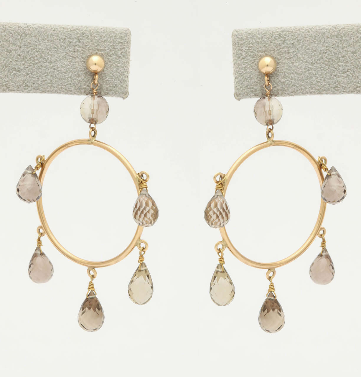 Hoop earrings are always in style for day or night. These smoky quartz drops, also known as smoky topaz, are micro-faceted  briolettes. They dangle from the 1 in. in diameter hoops and sparkle with every head movement. They are on a ball and post