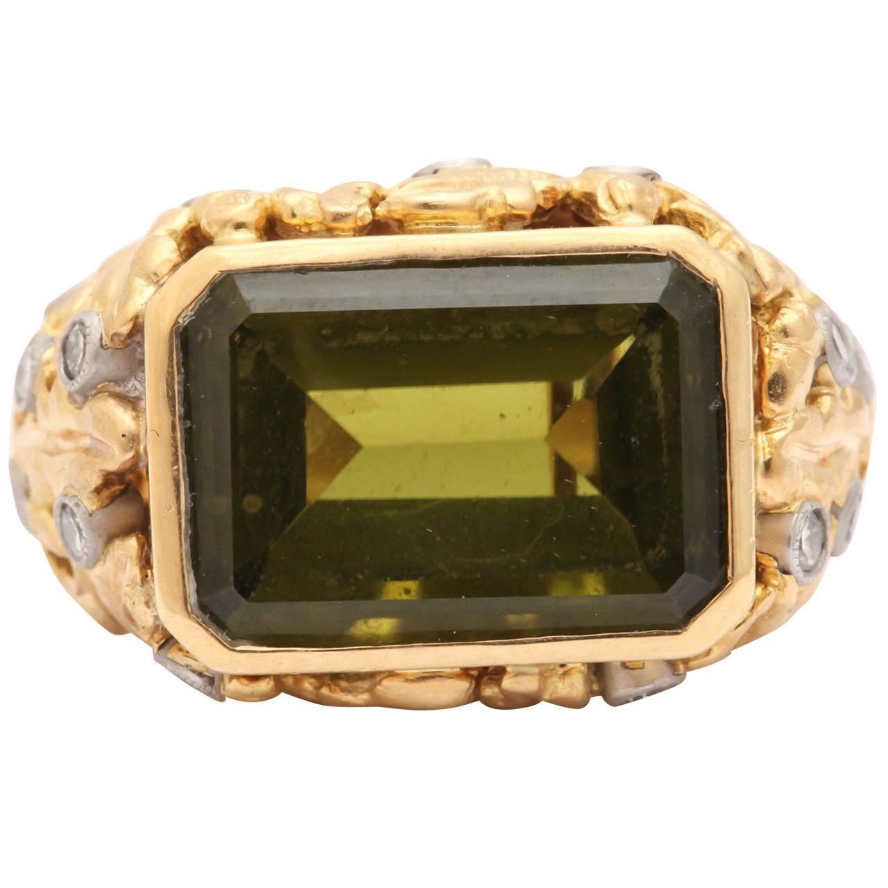 This fine gemstone is a true Olivine, very rare in larger sizes. It is a wonderful color like the  best extra virgin olive oil. The more common peridot is a form of olivine but lighter in color. The stone is a striking emerald cut and is 11 cts ,