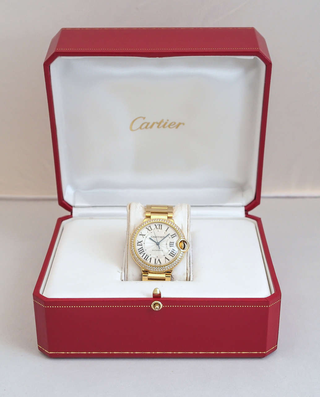 Cartier 18k yellow gold and diamond Ballon Bleu wristwatch, Ref. WE9004Z3, serial number 82288PX 3002
Dial: Silvered dial, Roman numerals, diamonds on the bezel, blued-steel sword hands, gold crown set with a blue cabochon sapphire
Features:
