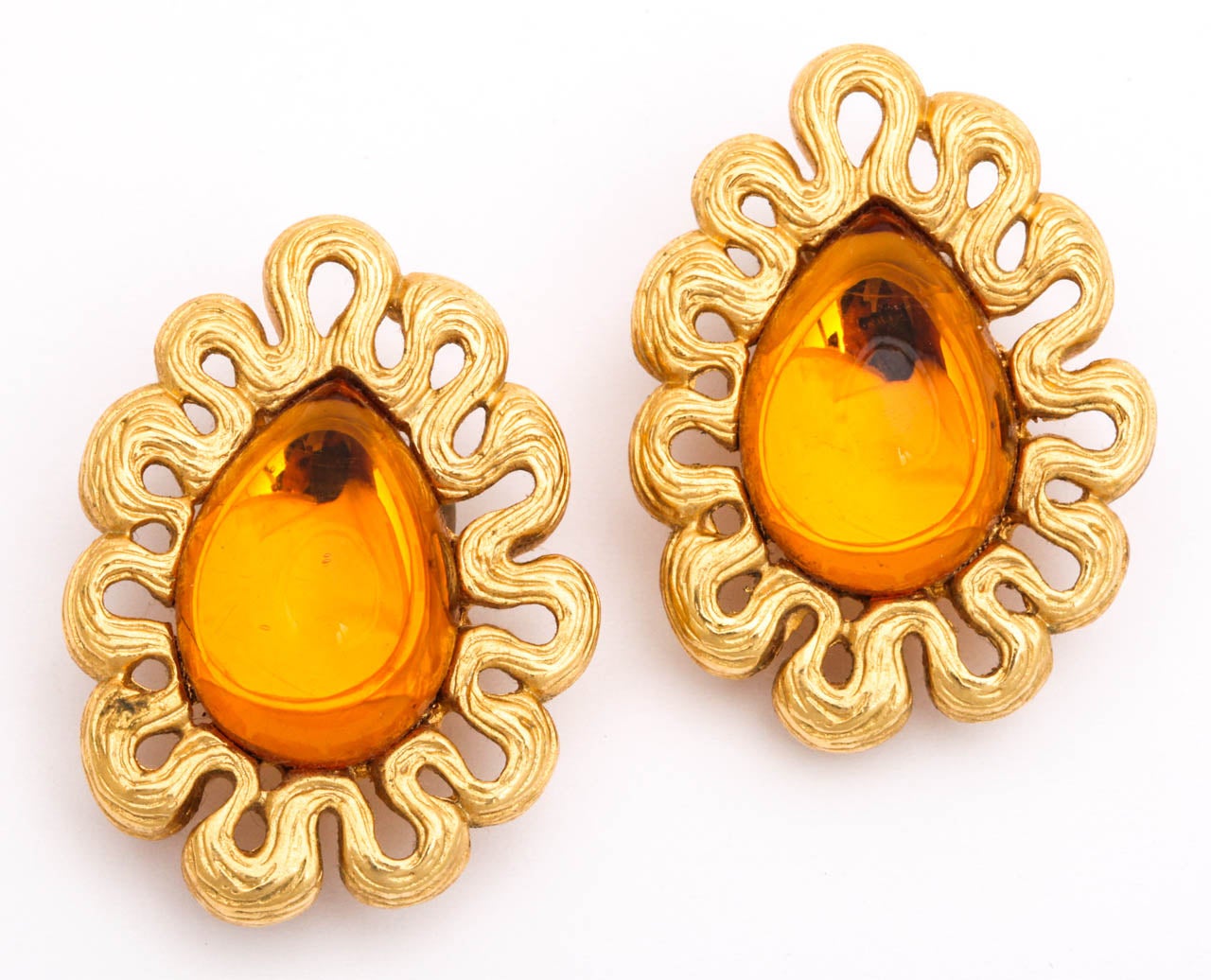 Large pear shaped amber colored stone with undulating gold tone frame. Marked Givenchy, Paris, New York, and logo.