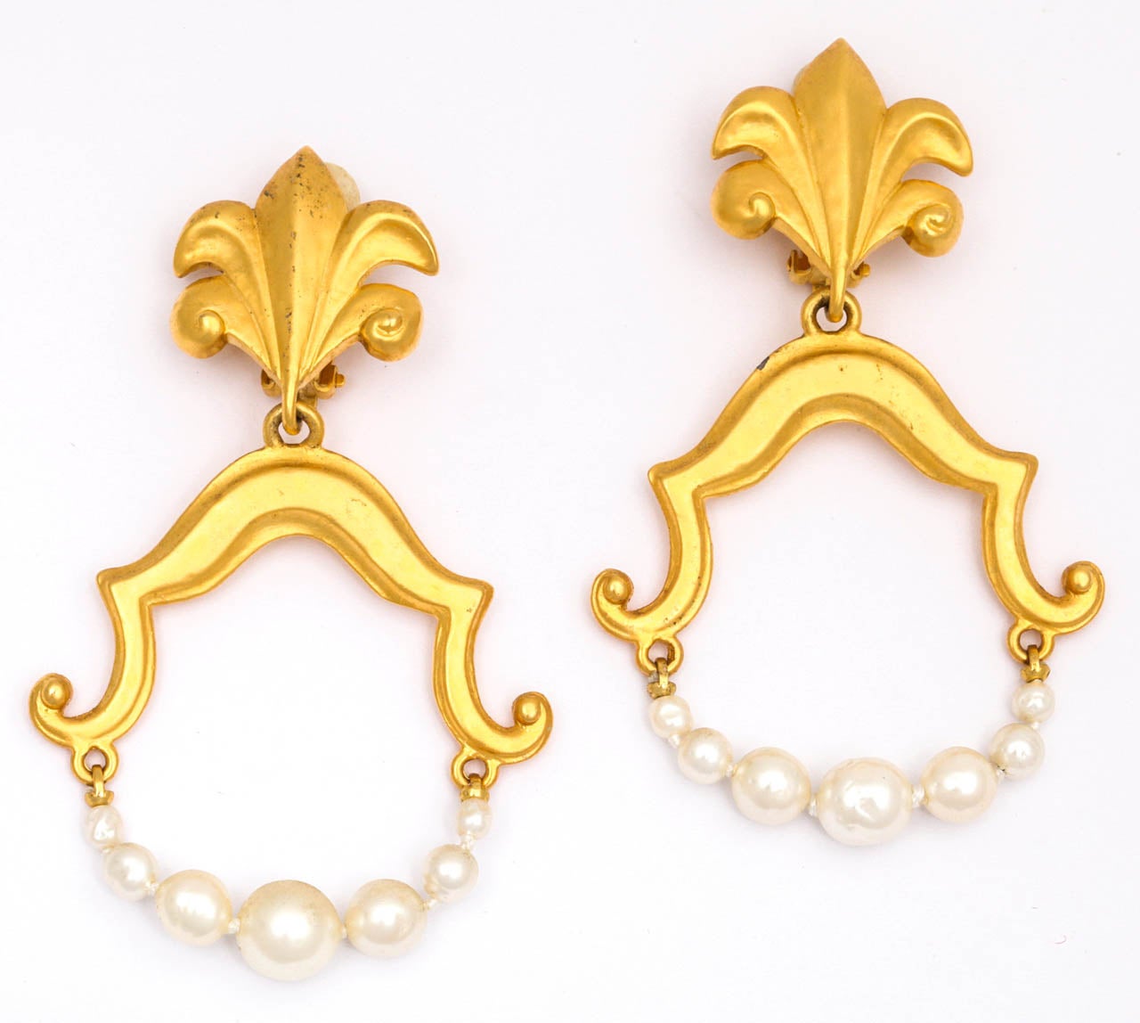 Baroque style gold tone and graduated pearl hoop earrings with a fleur de lis type clip.