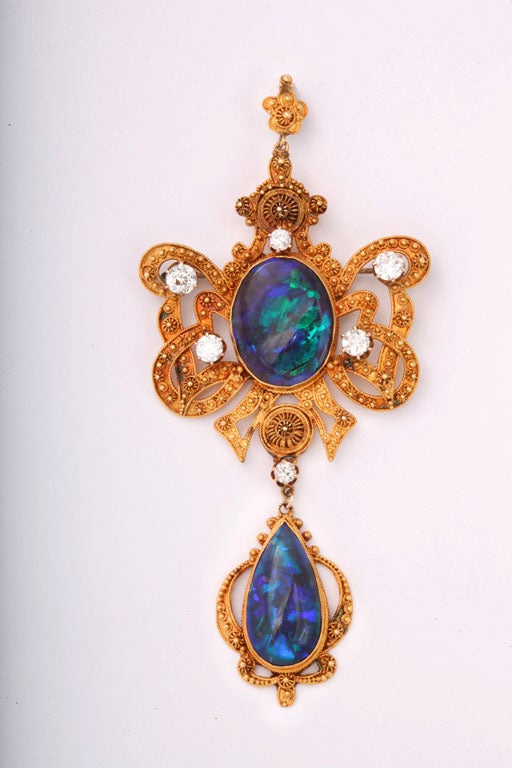 Very Fine 1950's Etruscan  Revival Australian Black Opal Diamond Brooch / Pendant featuring an open frame stylized knotted bow design centrally set with two black opals exhibiting a very fine 