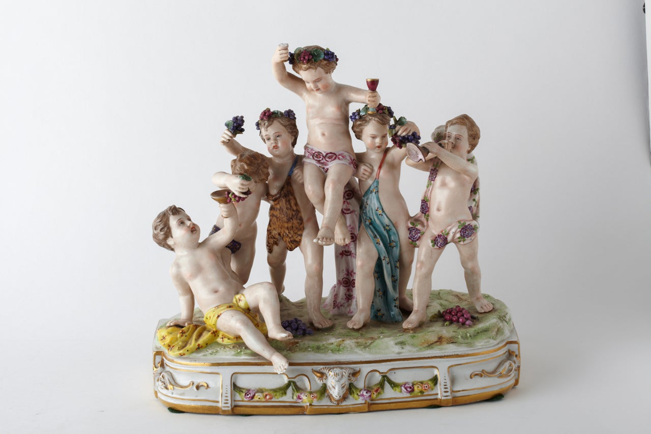 This porcelain group represents Baccanalean putti celebrating, drinking wine and eating grapes. Signed by Capodimonte.