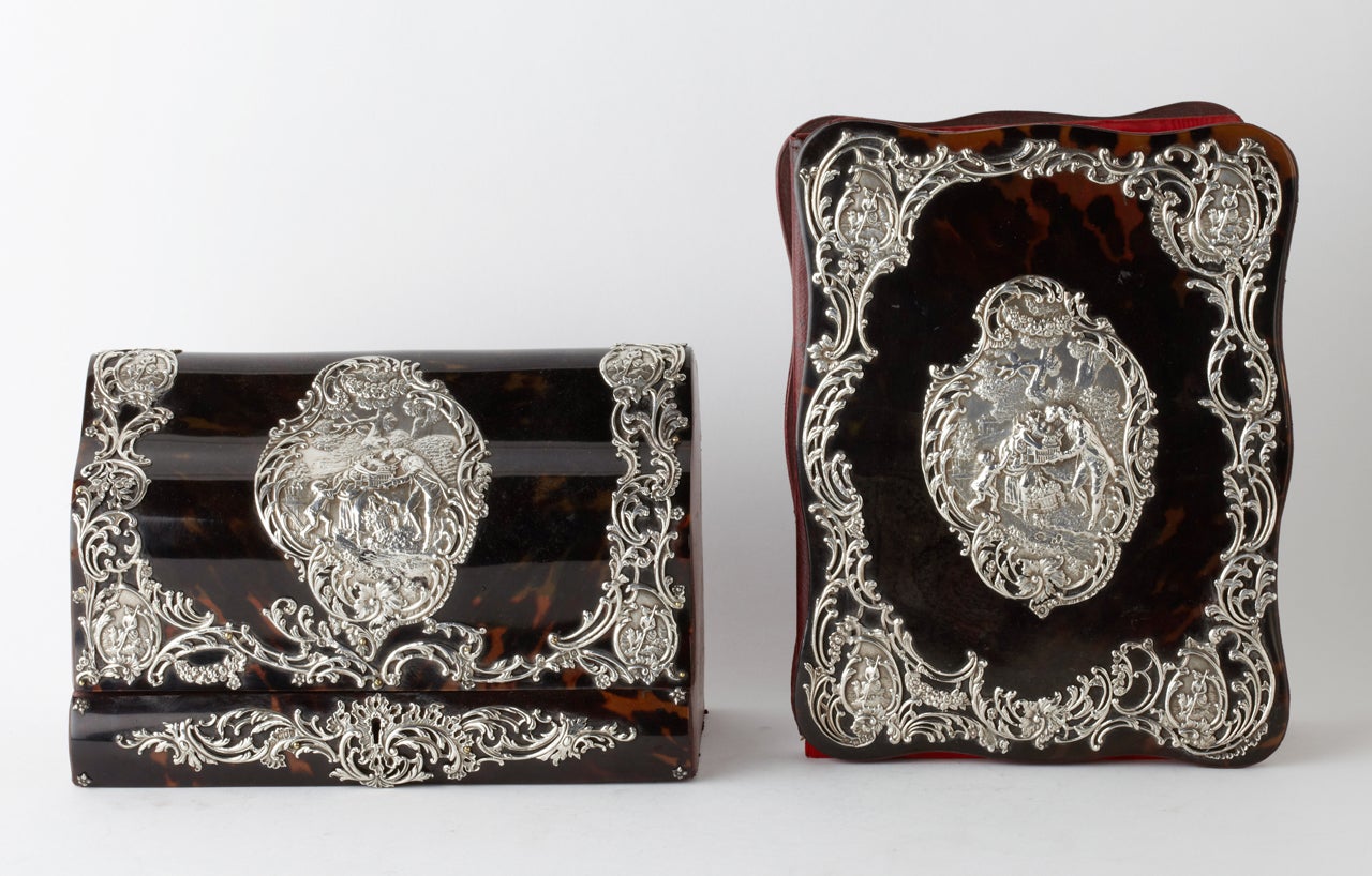 The set is comprised of a blotter and letter box in leather, tortoiseshell and sterling silver. The decorations represent family and rural scenes.

Fully marked London, 1915, by William Commins.

Measurements Box: 7,5 inch H 11,5 inch L 5,5 inch