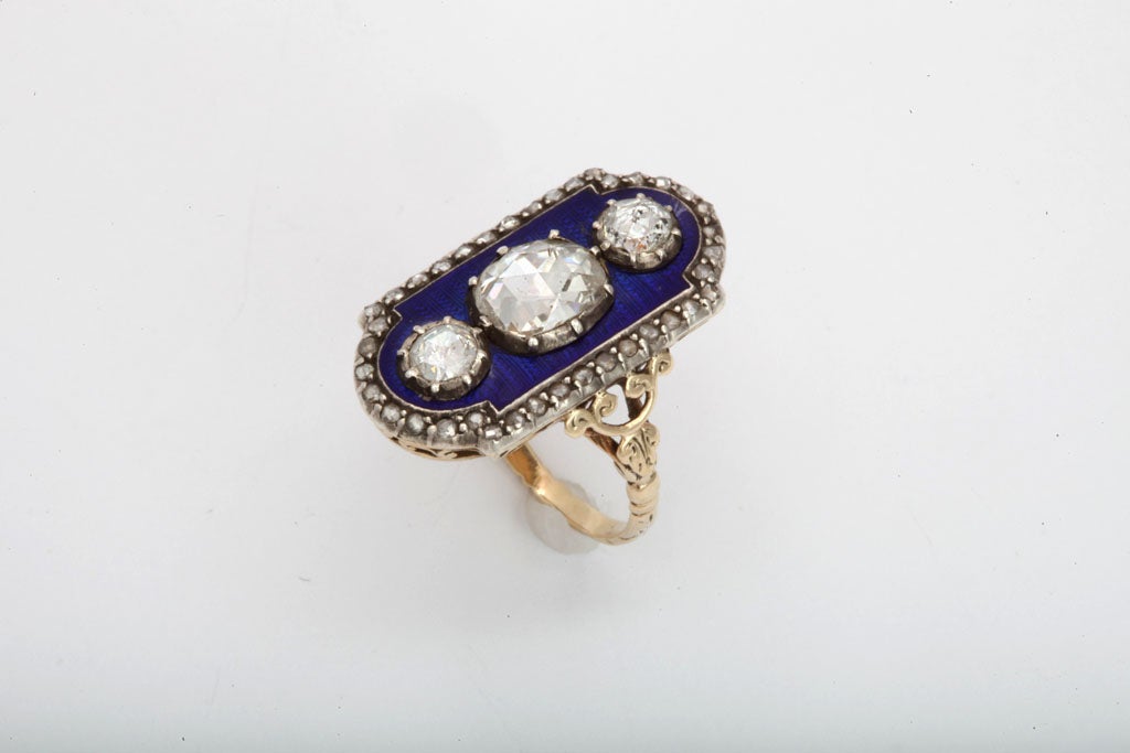 The contrast of color is striking in this late 18th century treasure of a ring. Dark royal blue enamel is the background for three bright antique rose cut diamonds of approximately two carats in weight.  The stone settings are crimped around the