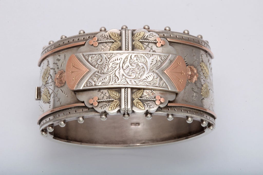 Forget-me-nots and roses adorn this decorative, superb example of English silver.  Every engraved spot shows a leaf or flower. Even the rose gold triangles on the center applied plaque are engraved with tiny for-get-me nots. The generous gold